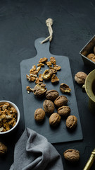 Orzechy włoskie leżące na czarnej kamiennej desce. Widok z góry.