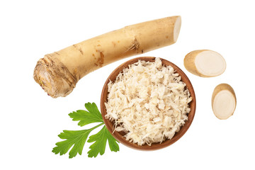Horseradish root grated in wooden bowl with slices isolated on white background. Top view. Flat lay