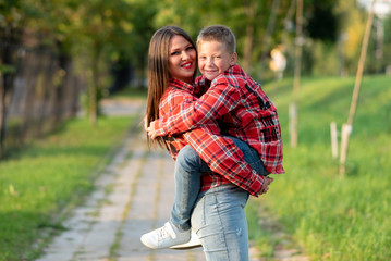 Fototapeta premium Mom with a smile holds her son in her arms.