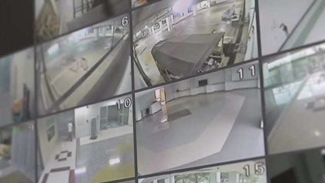 Closeup on split screen CCTV monitor viewing office building at night, Surveillance security camera monitoring system