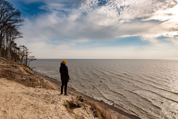 Person from behind and sandy beach in the coast of Baltic sea in Palanga, Lithuania.