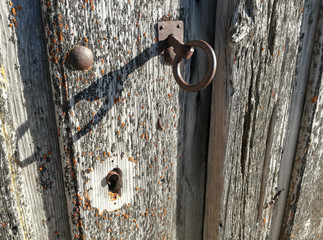 Central part of an old wooden door of an agricultural village in the middle of the Iberian Peninsula, Europe. Ancient forges. Huge lock.