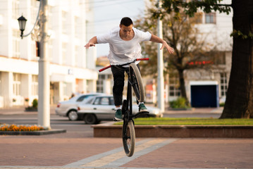 The guy on the BMX bike, releases his hands in a jump.