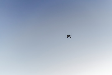 Airplane flight in the clear summer sky, view from the ground