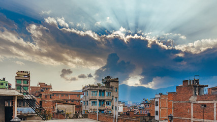 Colourful buildings of Kathmandu , the capital of Nepal. Dramatic Sunset sky with sun beams breaking out the clouds.