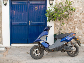 blue scooter by a blue door