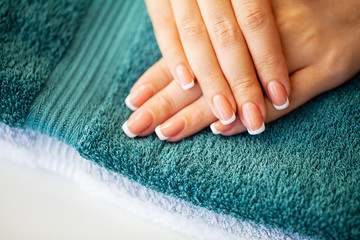 Beautiful woman's nails with french manicure, in beauty studio
