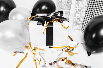 White gift box with black ribbon, bags and black balloons on white background. Gifts, Black Friday, holiday, discounts