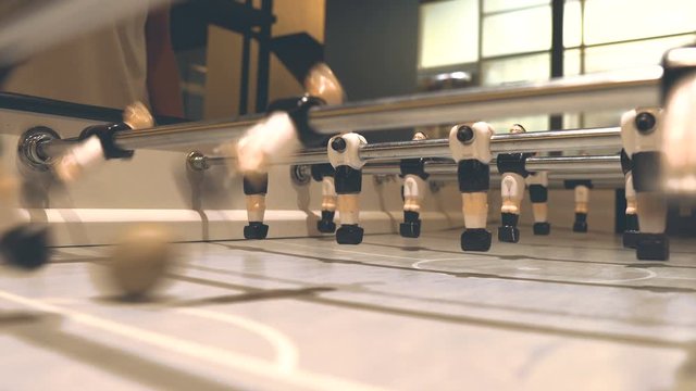 "People playing soccer table game with colleague at co working space office in break free time, relax with friends, close up low angle shot miniature 