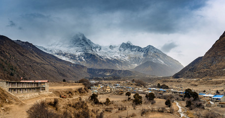 Village in beautiful Himalaya mountains covered with snow and wrapped in fog, Manaslu Circuit Trek.