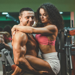 Fototapeta na wymiar sportive couple in gym . muscular woman and man in gym.sportive life. fitness. gym. hot curly woman. handsome bodybuilder
