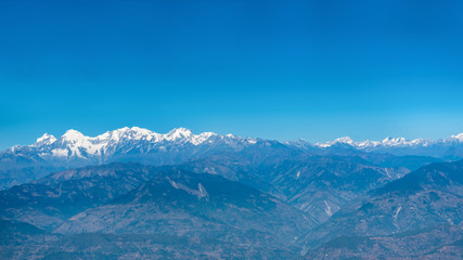 Aerial view from a plane over Himalaya mountains on a bright sunny morning.