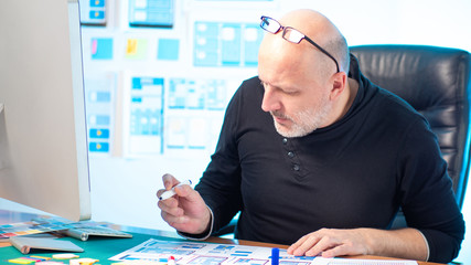 UX design. The man at the desk. Designer at work. The process of creating applications. The man in...