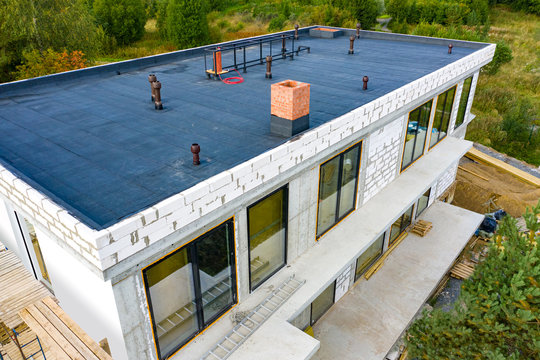 Roof waterproofing. The roof of the building is covered with a waterproofing layer. Building. Low-rise construction.  The roof of the building under construction.  Unclad cottage.