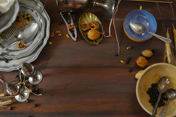 Messy table filled with various dishes with nuts scattered around. Shot from above. It appears to be shot after a big meal like Thanksgiving. Lighting from side window. Copy space.