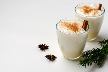 Eggnog with cinnamon and nutmeg for christmas and winter holidays. Eggnog isolated on white background.