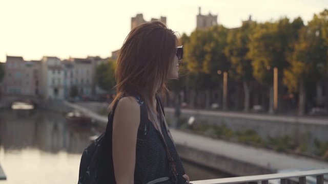A beautiful woman tourist walks through the historical center of the French city of Narbonne. River canal in the city center