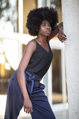 Fototapeta na wymiar A young fashionable Afro-American woman posing outside the financial building