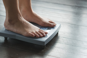 Woman measuring weight on weight scale have a copy space for text.