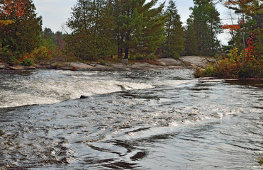Waterfall along a river in autumn