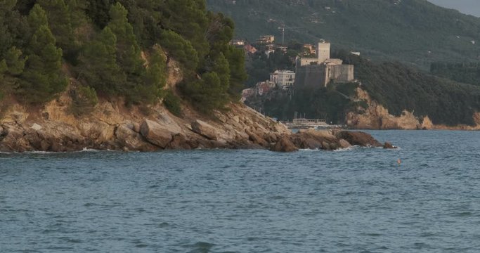 Lerici castle near the Cinque Terre illuminated by the light of the sunset.  The fortress on the rock overlooking the blue sea of the Gulf of La Spezia. 