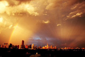 Sunset with a rainbow over the buldings and the Cathedral of Maringa, Parana, Brazil