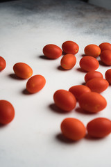 grape tomatoes scattered on white background