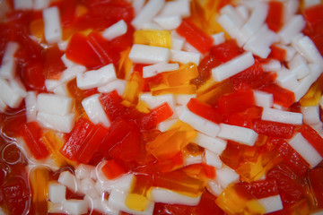 Cube coconut jelly in red syrup for eat with ice, Thai dessert.
