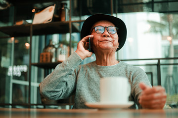 Asian senior man drinking coffee in coffee shop cafe