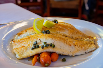 Close up shot of fried fish with lemon and vegetable
