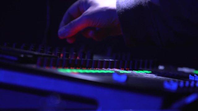 DJ turning knobs on mixer