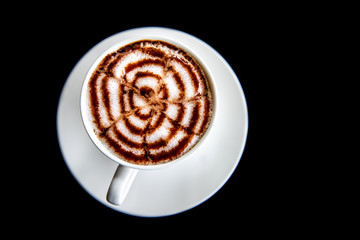 Hot art Mocha Coffee in a cup on black table. Image on top view.