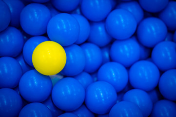 Close up of plastic yellow and blue balls at the playground. Soft focus.