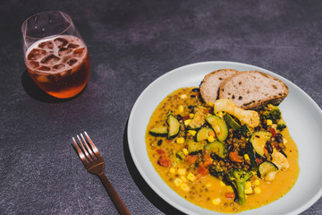 healthy vegan lentil soup with mixed veggies in curry sauce and bread