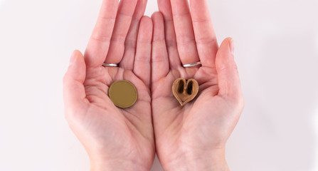 Woman holding hazelnut heart and coin in hands.Love Concept. A Perfect Gift or Present for Someone Special. Donate help give love warmth take care .Valentines Day background.