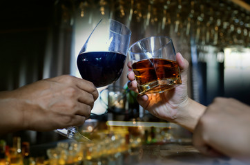 food and drink male friends are happy drinking beer and clinking glasses at a bar or pub.