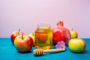 Jar of honey, apples and pomegranates on the table for the holiday of Rosh Hashanah