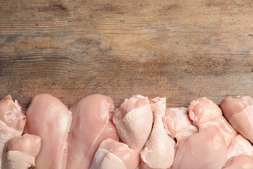 Fresh chicken meat on wooden table, flat lay. Space for text