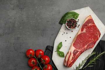 Flat lay composition with fresh meat on grey table. Space for text