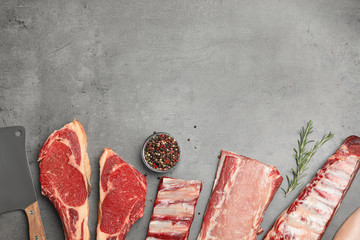 Flat lay composition with fresh meat on grey table. Space for text