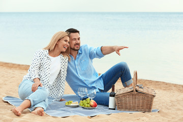 Happy romantic couple having picnic at beach