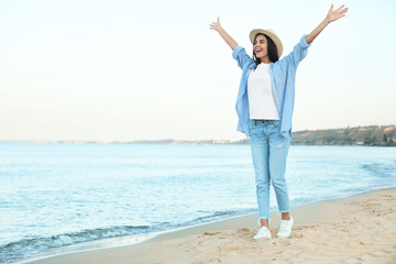 Beautiful young woman in casual outfit on beach