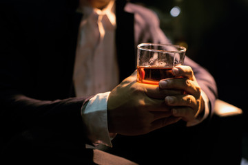 Closeup businessmen holding a glass of whiskey 