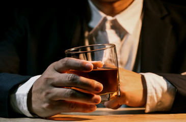 Closeup businessmen holding a glass of whiskey