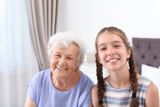 Happy cute girl with her grandmother at home