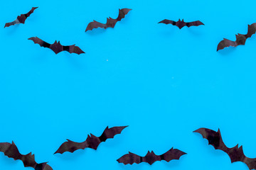 Bats cutout on Halloween frame on blue table top view copy space