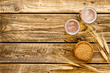 Beer ingredients. Barley near beer glasses on rustic wooden background top view copy space
