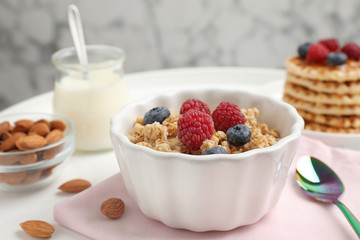 Healthy breakfast with granola and berries served on white table