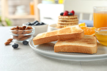 Fototapeta na wymiar Delicious breakfast with toasted bread served on light table, closeup