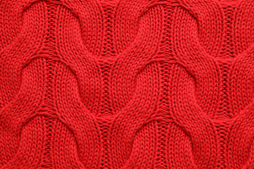 Red winter sweater as background, closeup view